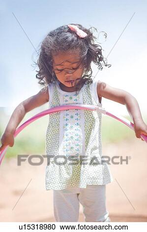 Girl playing with hula hoop outdoors View Large Photo Image Stock Image - Girl playing with hula hoop outdoors. Fotosearch