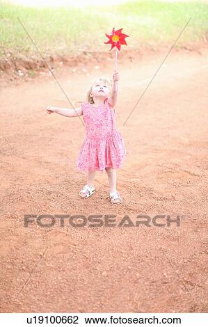 Girl playing with pinwheel on dirt road View Large Photo Image Stock Image - Girl playing with pinwheel on dirt road. Fotosearch
