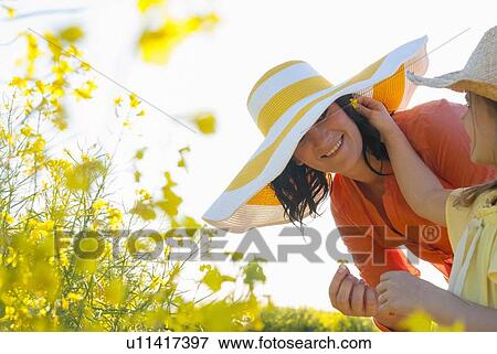 Girl putting flower in mothers hair View Large Photo Image Stock Photo - Girl putting flower in mothers hair. Fotosearch