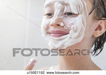 Girl rubbing moisturizer on her face View Large Photo Image Stock Image - Girl rubbing moisturizer on her face. Fotosearch