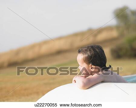 Stock Photography - Girl sitting in wading pool outdoors. Fotosearch