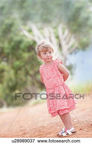 Girl standing on dirt road View Large Photo Image Stock Photo - Girl standing on dirt road. Fotosearch