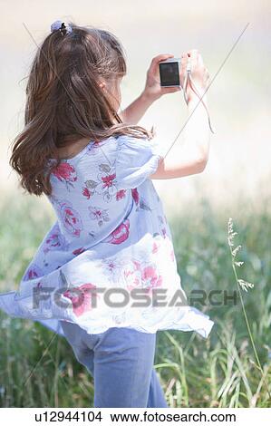 Girl taking pictures in tall grass View Large Photo Image Picture - Girl taking pictures in tall grass. Fotosearch