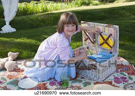 Girl unpacking picnic basket in field View Large Photo Image Stock Image - Girl unpacking picnic basket in field. Fotosearch