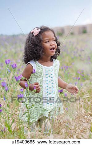 Girl walking in field of flowers View Large Photo Image Stock Photography - Girl walking in field of flowers. Fotosearch