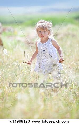 Girl walking in tall grass View Large Photo Image Stock Image - Girl walking in tall grass. Fotosearch