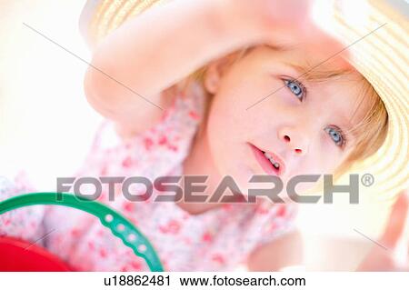 Stock Image - Girl wearing sun hat outdoors. Fotosearch