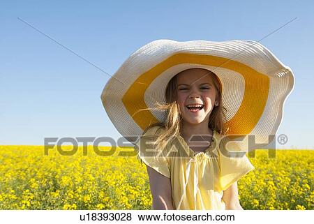 Stock Photo - Girl wearing sun hat outdoors. Fotosearch