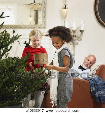 Girls decorating Christmas tree View Large Photo Image Stock Photo - Girls decorating Christmas tree. Fotosearch