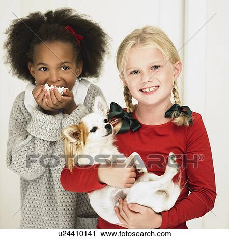 Girls eating popcorn and holding dog View Large Photo Image Stock Image - Girls eating popcorn and holding dog. Fotosearch