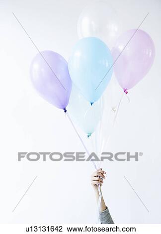 Hand holding bunch of balloons View Large Photo Image Stock Image - Hand holding bunch of balloons. Fotosearch