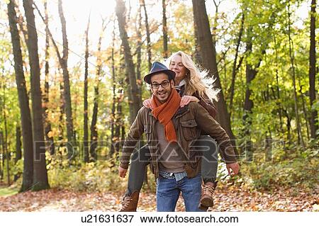Stock Photo - Man carrying girlfriend in forest. Fotosearch