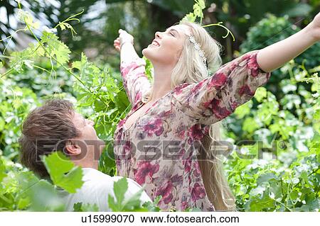 Man carrying girlfriend in tall plants View Large Photo Image Stock Image - Man carrying girlfriend in tall plants. Fotosearch