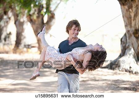 Man carrying girlfriend outdoors View Large Photo Image Stock Image - Man carrying girlfriend outdoors. Fotosearch