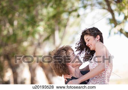 Man carrying girlfriend outdoors View Large Photo Image Stock Photo - Man carrying girlfriend outdoors. Fotosearch