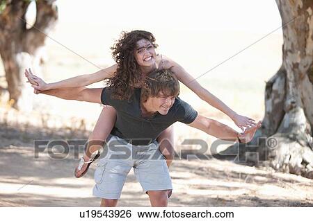 Man carrying girlfriend outdoors View Large Photo Image Stock Photograph - Man carrying girlfriend outdoors. Fotosearch