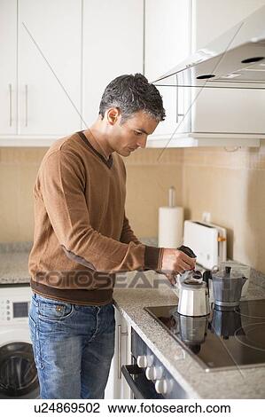 Man making coffee in kitchen View Large Photo Image Stock Image - Man making coffee in kitchen. Fotosearch