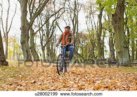 Stock Photo - Man riding bicycle in park. Fotosearch