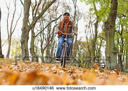 Man riding bicycle in park View Large Photo Image Stock Photograph - Man riding bicycle in park. Fotosearch