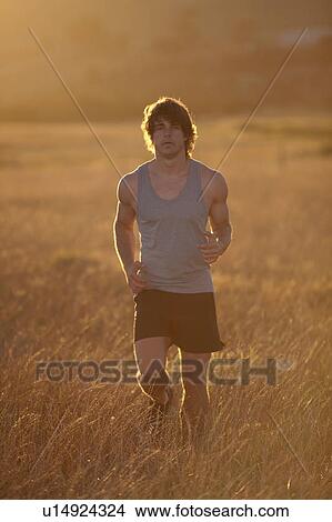 Man running in tall grass at sunset View Large Photo Image Picture - Man running in tall grass at sunset. Fotosearch