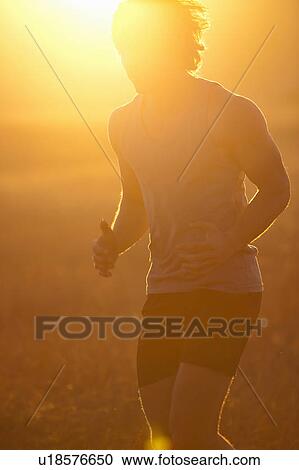 Man running in tall grass at sunset View Large Photo Image Stock Image - Man running in tall grass at sunset. Fotosearch