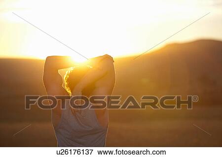 Man stretching in field at sunset View Large Photo Image Stock Photo - Man stretching in field at sunset. Fotosearch