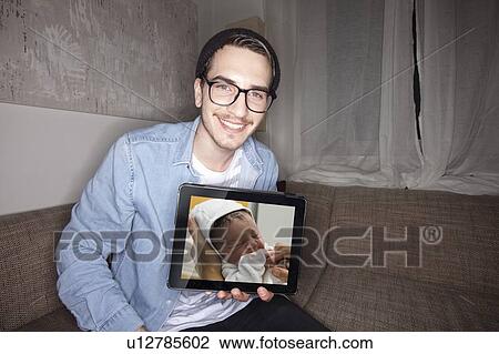 Man with newborn on tablet computer View Large Photo Image Stock Image - Man with newborn on tablet computer. Fotosearch