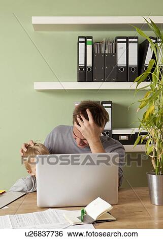 Man working at laptop with son View Large Photo Image Stock Photograph - Man working at laptop with son. Fotosearch
