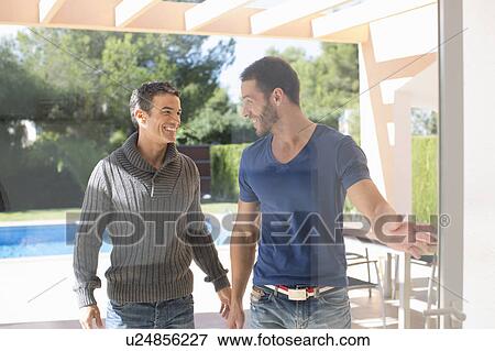 Stock Photo - Men opening glass door in backyard. Fotosearch