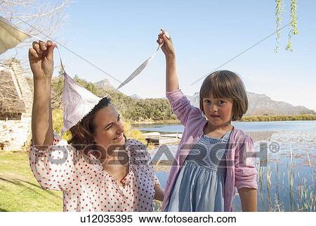 Mother and daughter hanging bunting View Large Photo Image Stock Photography - Mother and daughter hanging bunting. Fotosearch