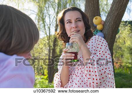 Stock Image - Mother and daughter having picnic. Fotosearch