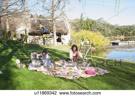 Stock Image - Mother and daughter having picnic. Fotosearch