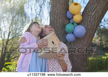 Mother and daughter holding birdhouse View Large Photo Image Stock Photo - Mother and daughter holding birdhouse. Fotosearch