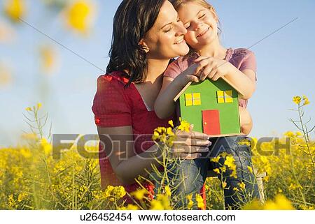 Mother and daughter holding model house View Large Photo Image Picture - Mother and daughter holding model house. Fotosearch