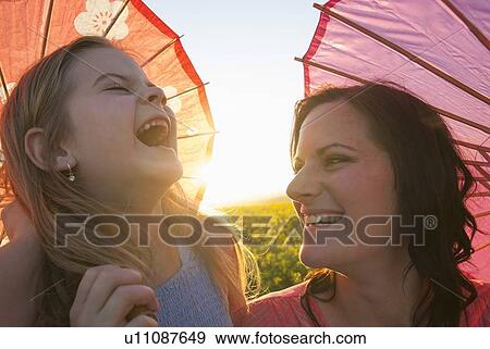 Stock Photo - Mother and daughter holding parasols. Fotosearch