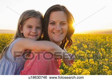 Stock Photograph - Mother and daughter hugging outdoors. Fotosearch