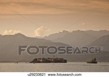 Stock Image - Mountains over rural village and lake. Fotosearch