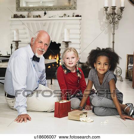 Older man and girls with Christmas gifts View Large Photo Image Stock Photo - Older man and girls with Christmas gifts. Fotosearch
