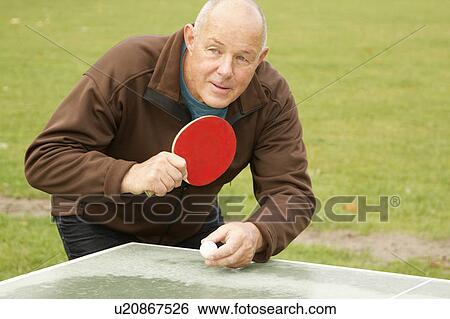 Older man playing ping pong outdoors View Large Photo Image Stock Photograph - Older man playing ping pong outdoors. Fotosearch