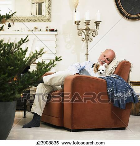 Stock Photography - Older man sleeping by Christmas tree. Fotosearch