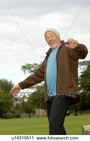Stock Image - Older man walking outdoors. Fotosearch