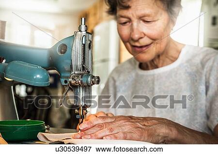 Older woman working on sewing machine View Large Photo Image Stock Photo - Older woman working on sewing machine. Fotosearch