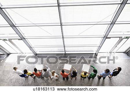 Stock Image - Overhead view of people passing boxes. Fotosearch