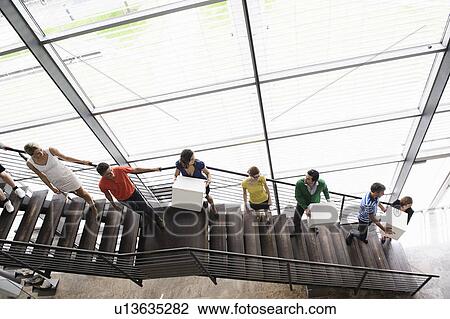Stock Image - People passing boxes up stairs. Fotosearch