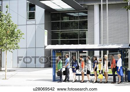 Stock Image - People waiting at bus stop. Fotosearch