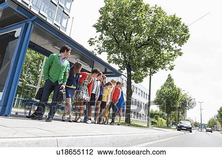 Stock Image - People waiting at bus stops. Fotosearch