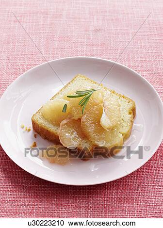 Stock Image - Plate of lemon cake with grapefruit. Fotosearch