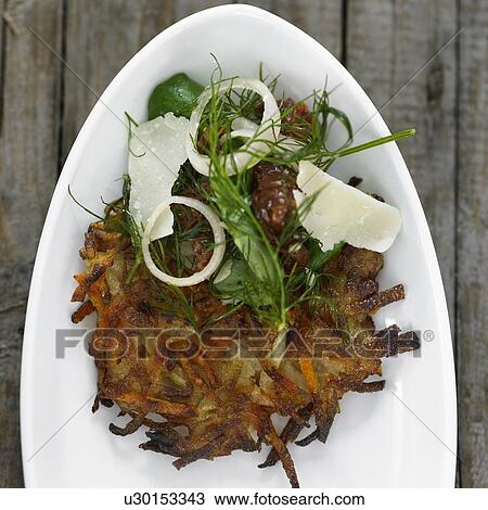 Stock Image - Plate of potato pancake with toppings. Fotosearch