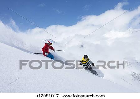 Skier and snowboarder on snowy slope View Large Photo Image Stock Photo - Skier and snowboarder on snowy slope. Fotosearch
