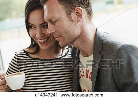 Stock Image - Smiling couple hugging in cafe. Fotosearch